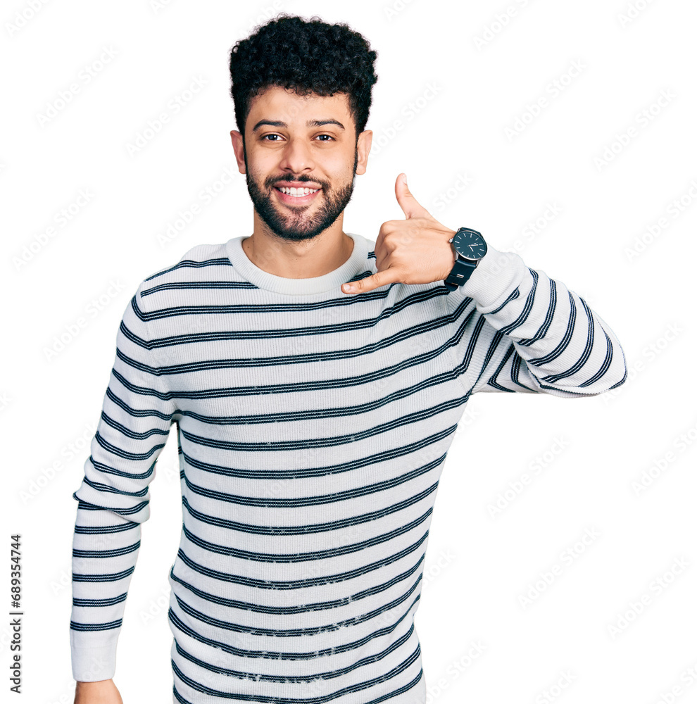 Fototapeta premium Young arab man with beard wearing casual striped sweater smiling doing phone gesture with hand and fingers like talking on the telephone. communicating concepts.