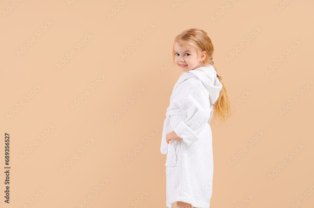 Cute little girl in bathrobe on beige background Cute little girl in bathrobe on beige background