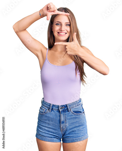 Young beautiful blonde woman wearing casual style with sleeveless shirt smiling making frame with hands and fingers with happy face. creativity and photography concept.