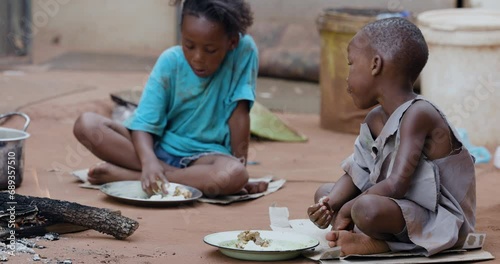 Wallpaper Mural Poverty,  poor, malnourished Black African children due to extreme poverty, drought and climate change. Sitting eating maize porridge. One fith of African children are undernourished. Torontodigital.ca