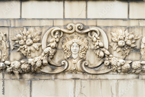 The facade of an old building decorated with a pattern of stucco. Mythical creatures on the facade of an old house.