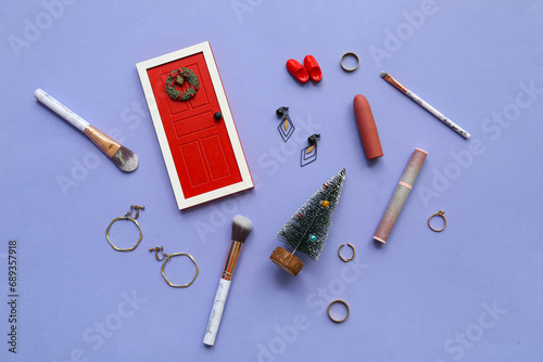 Christmas composition with makeup cosmetics, jewelry and decor on lilac background