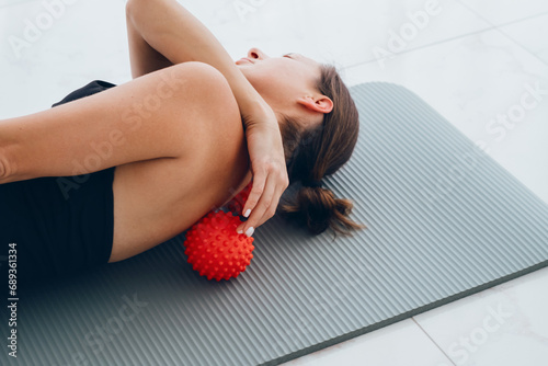 Woman lying on small balls to eliminate back pain, massage stiff muscles and thoracic back pain, perform exercises to relieve pain in spine. Relaxation and stretching of muscles photo