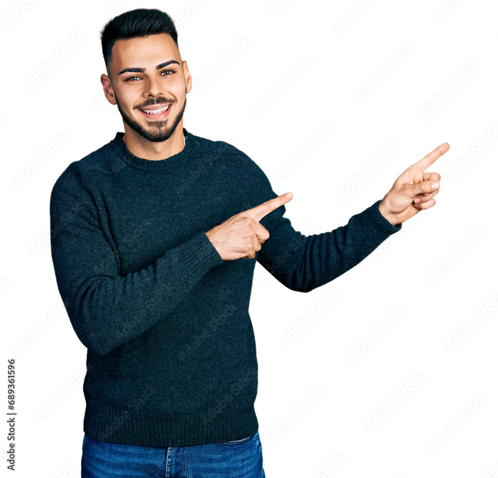 Young hispanic man with beard wearing casual winter sweater smiling and looking at the camera pointing with two hands and fingers to the side. Young hispanic man with beard wearing casual winter sweater smiling and looking at the camera pointing with two hands and fingers to the side.