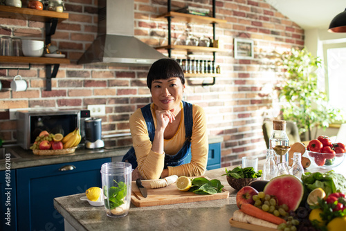 Portrait of young woman nutritionist in kitchen with fresh vegetables on countertop photo