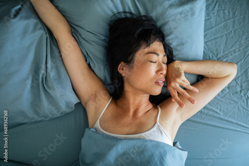 Asian Woman Asleep in Comfortable Bed photo
