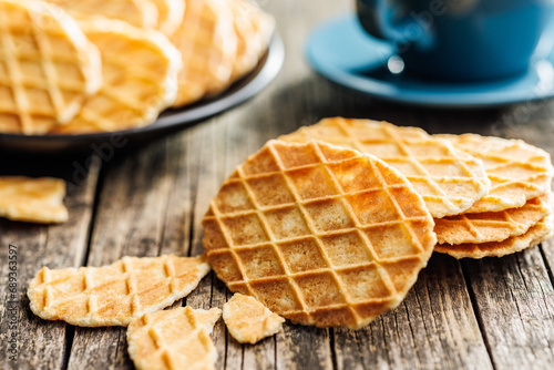 Round waffle biscuits on wooden table.