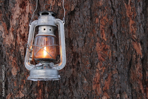 Εκτύπωση καμβά kerosene lamp shines on the bark of a pine tree in winter
