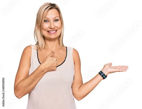 Middle age caucasian woman wearing casual clothes showing palm hand and doing ok gesture with thumbs up, smiling happy and cheerful © Krakenimages.com
