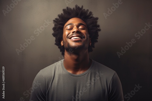 happy and jubilant young black man with his eyes closed smiling at the camera