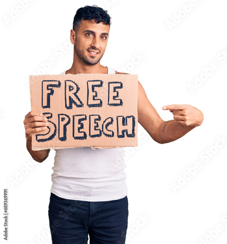 Young hispanic man holding free speech banner smiling happy pointing with hand and finger