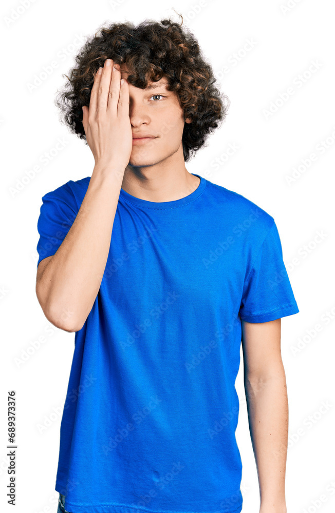 Caucasian teenager wearing casual clothes covering one eye with hand, confident smile on face and surprise emotion. Caucasian teenager wearing casual clothes covering one eye with hand, confident smile on face and surprise emotion.