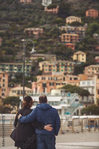 A couple lookig on the old coastal town background of Recco in Liguria, Italy. European italian vacation. Couple admires a beautiful view of the city. Romance, love and trusting relationships. © Cristina