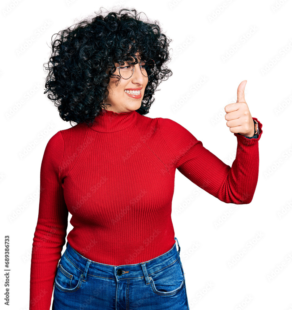 Young middle east girl wearing casual clothes and glasses looking proud, smiling doing thumbs up gesture to the side Young middle east girl wearing casual clothes and glasses looking proud, smiling doing thumbs up gesture to the side