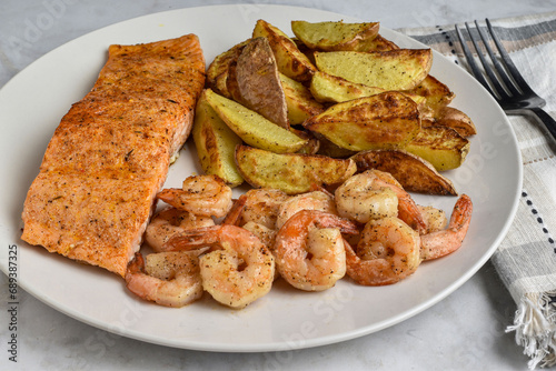 seasoned salmon  served with shrimp and potato wedges, photo