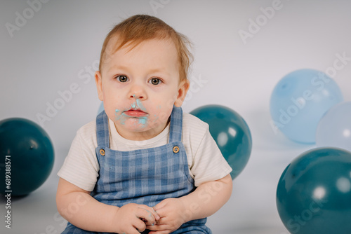 Baby boy playing with a cake during cake smash birthday party
