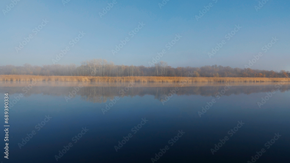 Morning on the river. Nature. Autumn. Reflection of trees in the water