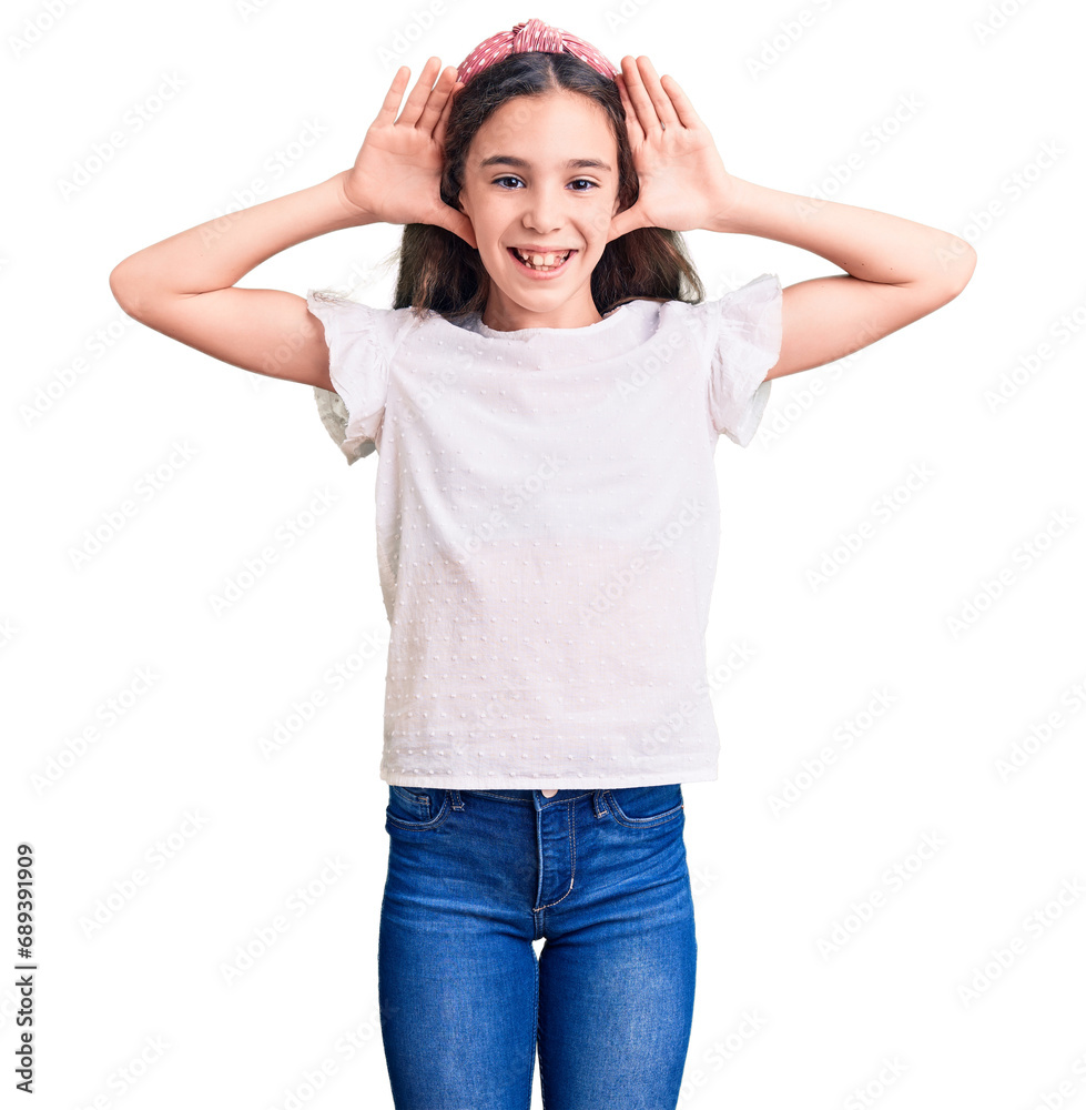 Cute hispanic child girl wearing casual white tshirt smiling cheerful playing peek a boo with hands showing face. surprised and exited Cute hispanic child girl wearing casual white tshirt smiling cheerful playing peek a boo with hands showing face. surprised and exited
