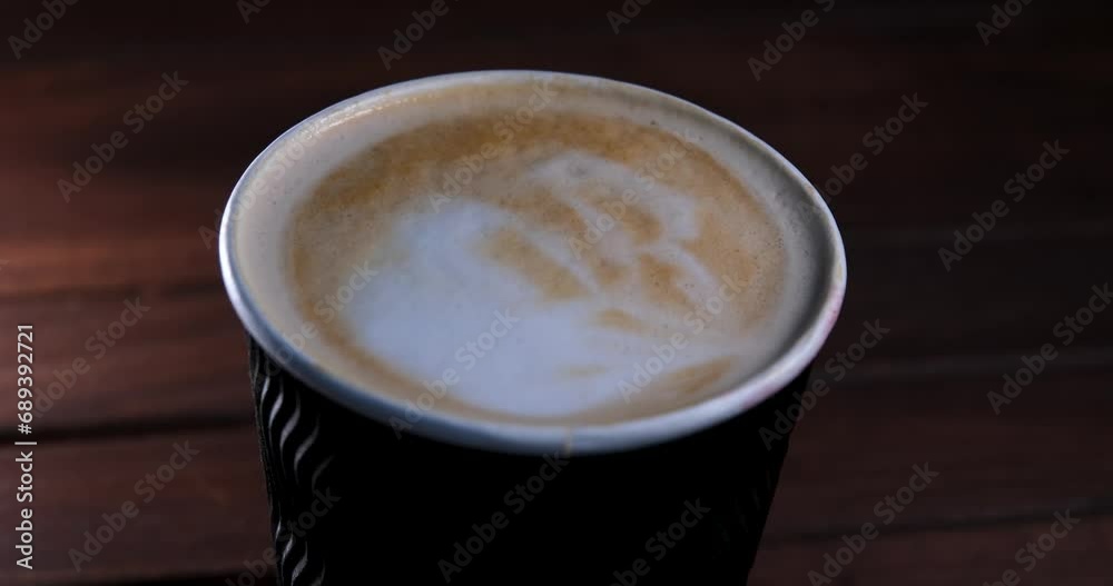 Close-up of a black coffee paper cup. The camera rotates around. Steam rises from the cup. Parallax effect. The concept of a coffee shop. Coffee as a way of life of modern man. Slow motion Close-up of a black coffee paper cup. The camera rotates around. Steam rises from the cup. Parallax effect. The concept of a coffee shop. Coffee as a way of life of modern man. Slow motion