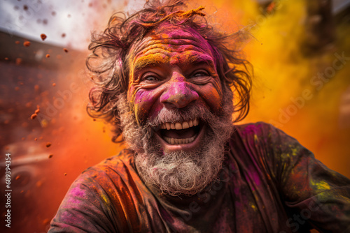 Cheerful look of a man with his face painted with orange tones in celebration of Holi Festival