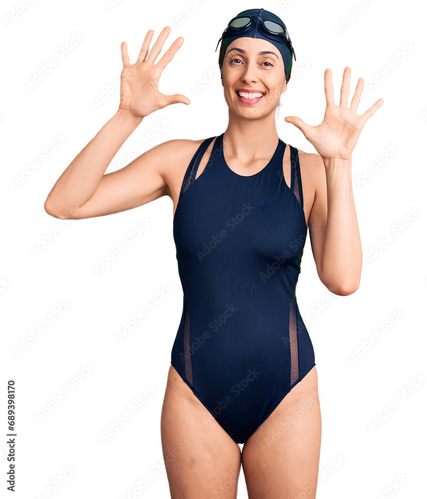 Young beautiful hispanic woman wearing swimwear and swimmer glasses showing and pointing up with fingers number ten while smiling confident and happy. Young beautiful hispanic woman wearing swimwear and swimmer glasses showing and pointing up with fingers number ten while smiling confident and happy.
