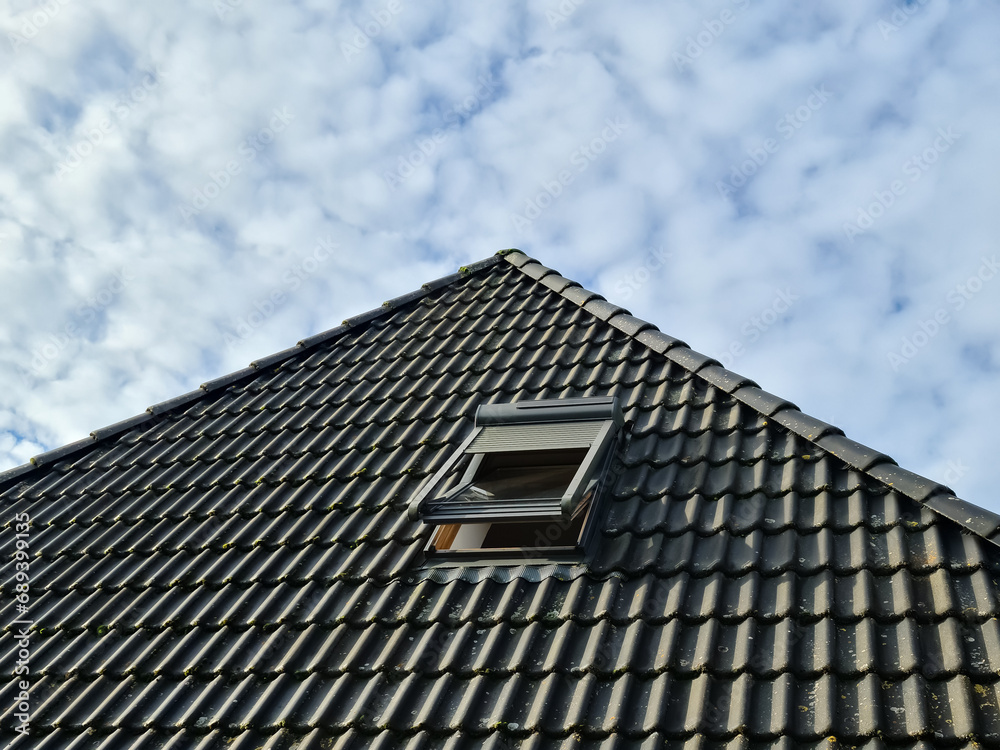Open roof window in velux style with black roof tiles. Open roof window in velux style with black roof tiles.