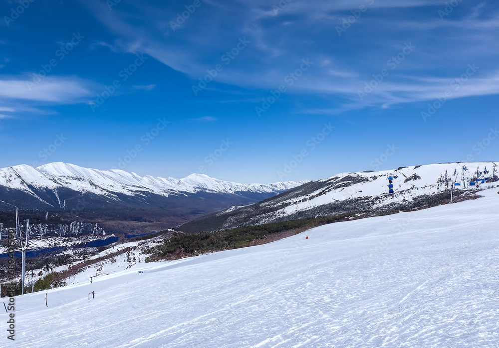 快晴、青空の背景のスキー場の写真　雪山ウィンタースポーツ　レジャー　スノーボード　AI生成画像