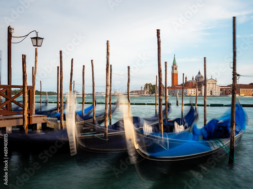 Gondolas moored by Saint Mark square with San Giorgio di Maggiore church in Venice, Italy © eplisterra