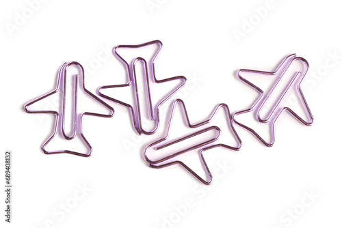 Purple paper clips in shape of airplanes on white background