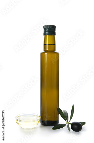 Glass bottle with olive oil, leaves and bowl on white background