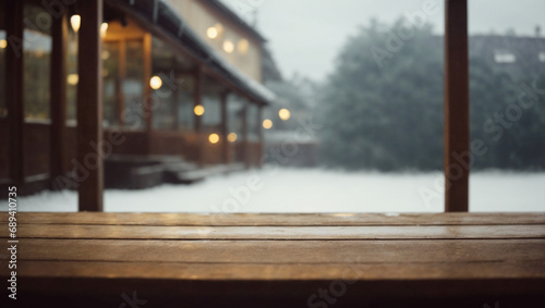 An empty wooden table with the snowy backyard of a house in the background during winter. Beginning of the year concept. photo