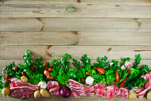 Raw mutton and vegetables assortment on natural wooden background, cooking ingredients