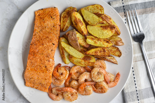seasoned salmon with  shrimp and potato wedges photo