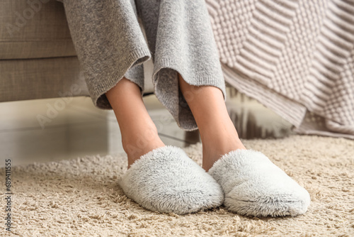 Young woman in fluffy slippers at home, closeup