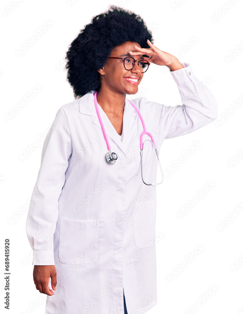 Young african american woman wearing doctor coat and stethoscope very happy and smiling looking far away with hand over head. searching concept. Young african american woman wearing doctor coat and stethoscope very happy and smiling looking far away with hand over head. searching concept.