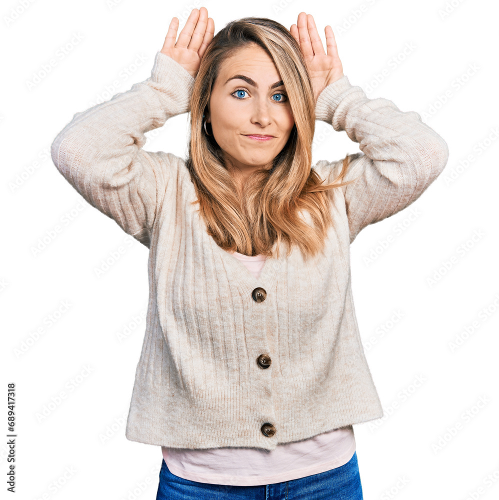 Young blonde woman wearing casual clothes doing bunny ears gesture with hands palms looking cynical and skeptical. easter rabbit concept. Young blonde woman wearing casual clothes doing bunny ears gesture with hands palms looking cynical and skeptical. easter rabbit concept.