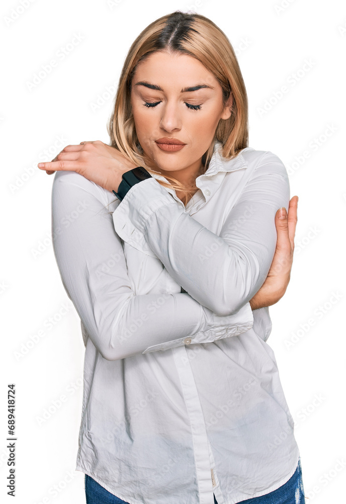 Young caucasian woman wearing casual clothes hugging oneself happy and positive, smiling confident. self love and self care Young caucasian woman wearing casual clothes hugging oneself happy and positive, smiling confident. self love and self care