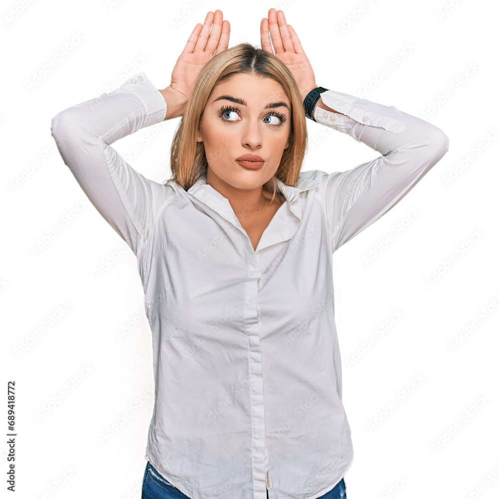 Young caucasian woman wearing casual clothes doing bunny ears gesture with hands palms looking cynical and skeptical. easter rabbit concept. Young caucasian woman wearing casual clothes doing bunny ears gesture with hands palms looking cynical and skeptical. easter rabbit concept.