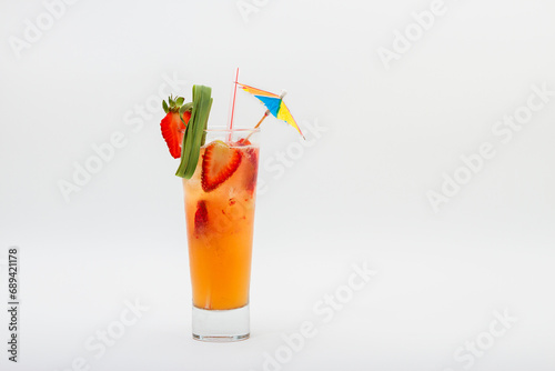 Cocktail drink with strawberries, straw and umbrella isolated on white background.