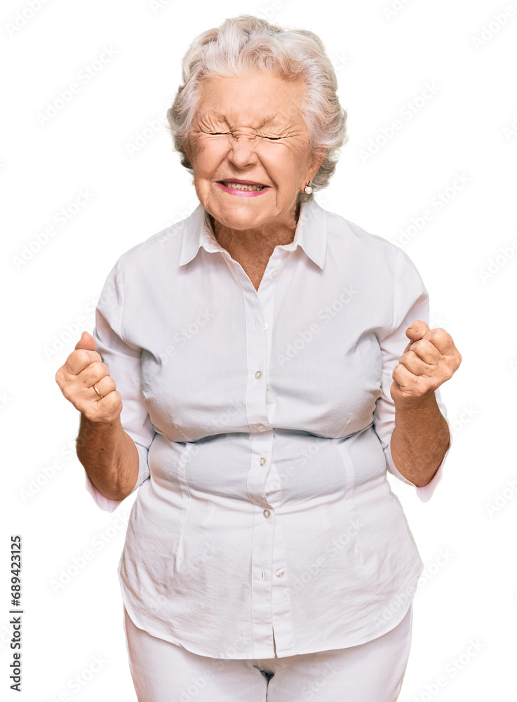 Senior grey-haired woman wearing casual clothes very happy and excited doing winner gesture with arms raised, smiling and screaming for success. celebration concept. Senior grey-haired woman wearing casual clothes very happy and excited doing winner gesture with arms raised, smiling and screaming for success. celebration concept.