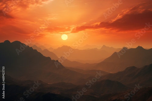 Sunset over mountainous terrain, the sky aflame with vibrant hues of orange and red.