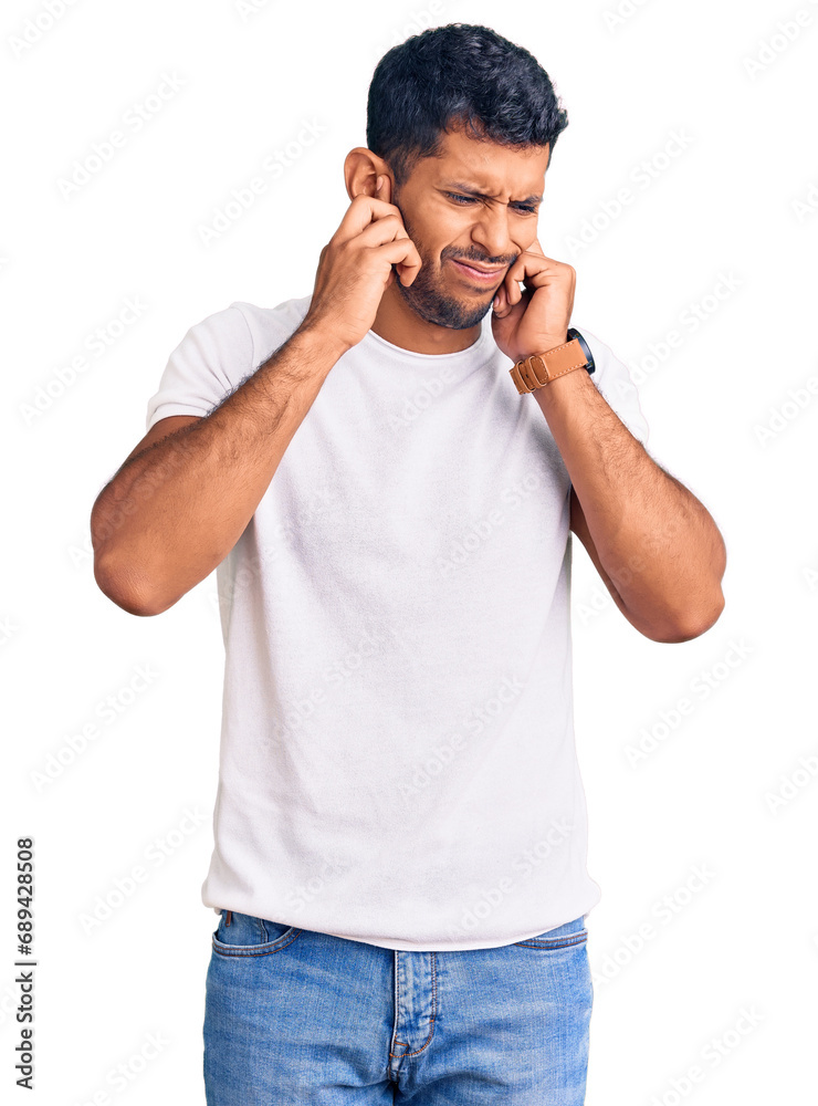 Young latin man wearing casual clothes covering ears with fingers with annoyed expression for the noise of loud music. deaf concept. Young latin man wearing casual clothes covering ears with fingers with annoyed expression for the noise of loud music. deaf concept.