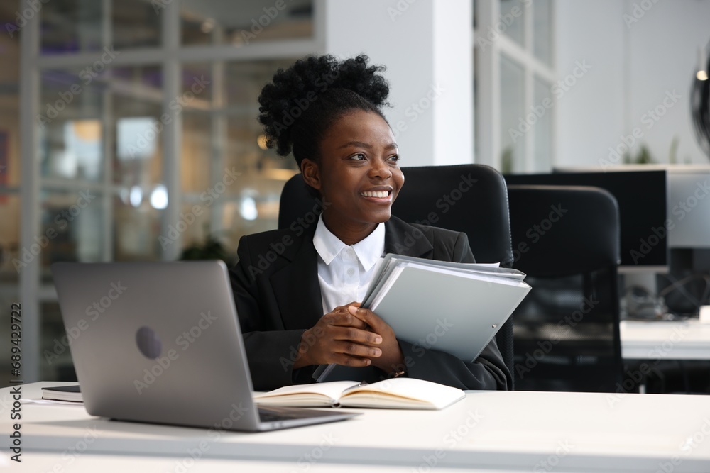 Happy woman with folders working at table in office. Lawyer, businesswoman, accountant or manager Happy woman with folders working at table in office. Lawyer, businesswoman, accountant or manager