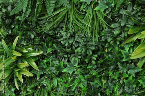Green artificial plant wall panel as background, closeup photo