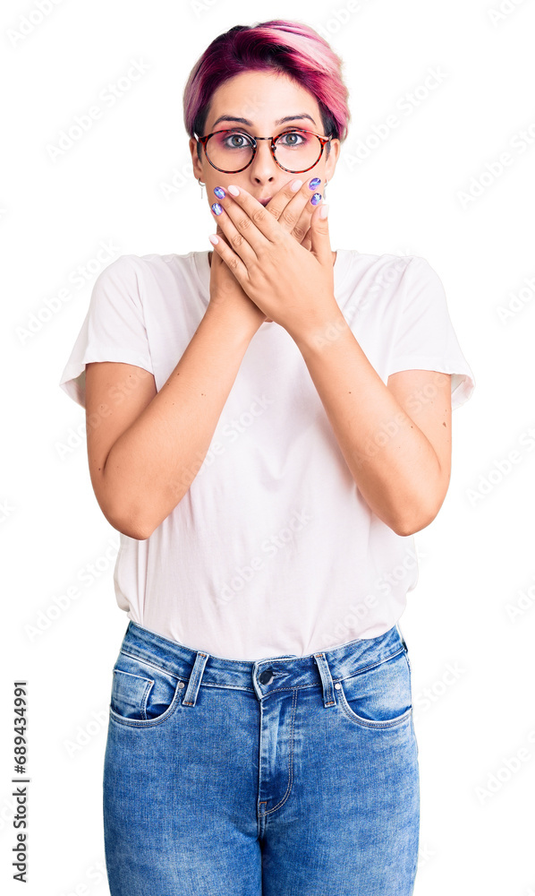 Young beautiful woman with pink hair wearing casual clothes and glasses shocked covering mouth with hands for mistake. secret concept.