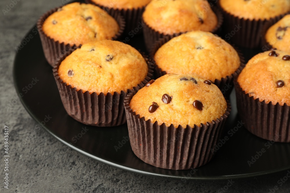 Delicious freshly baked muffins with chocolate chips on table, closeup