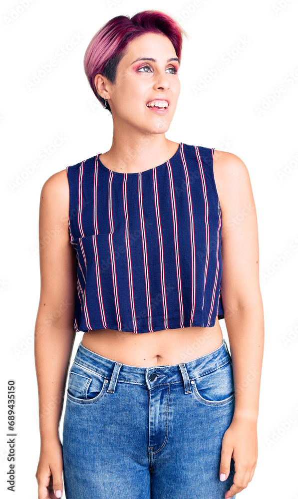 Young beautiful woman with pink hair wearing casual clothes looking away to side with smile on face, natural expression. laughing confident.