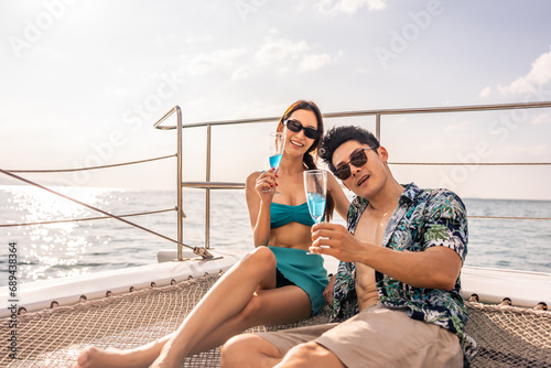 Portrait od Asian couple drink champagne while having party in yacht.  © Kawee