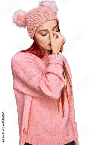 Young caucasian woman wearing casual clothes and wool cap tired rubbing nose and eyes feeling fatigue and headache. stress and frustration concept.