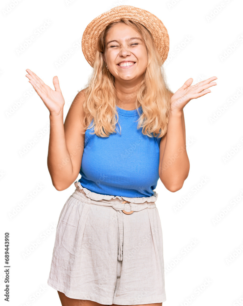 Young blonde girl wearing summer hat celebrating mad and crazy for success with arms raised and closed eyes screaming excited. winner concept Young blonde girl wearing summer hat celebrating mad and crazy for success with arms raised and closed eyes screaming excited. winner concept